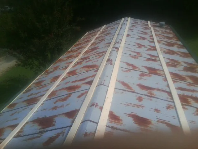 Rusted metal roof panels with new wood purlins before replacement — Storm Damage Roof Repair in Tarpon Springs by Roofing Brothers