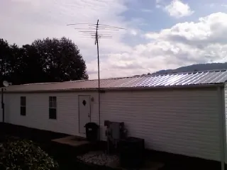 New metal roof on a single wide mobile home with a TV antenna in Tarpon Springs