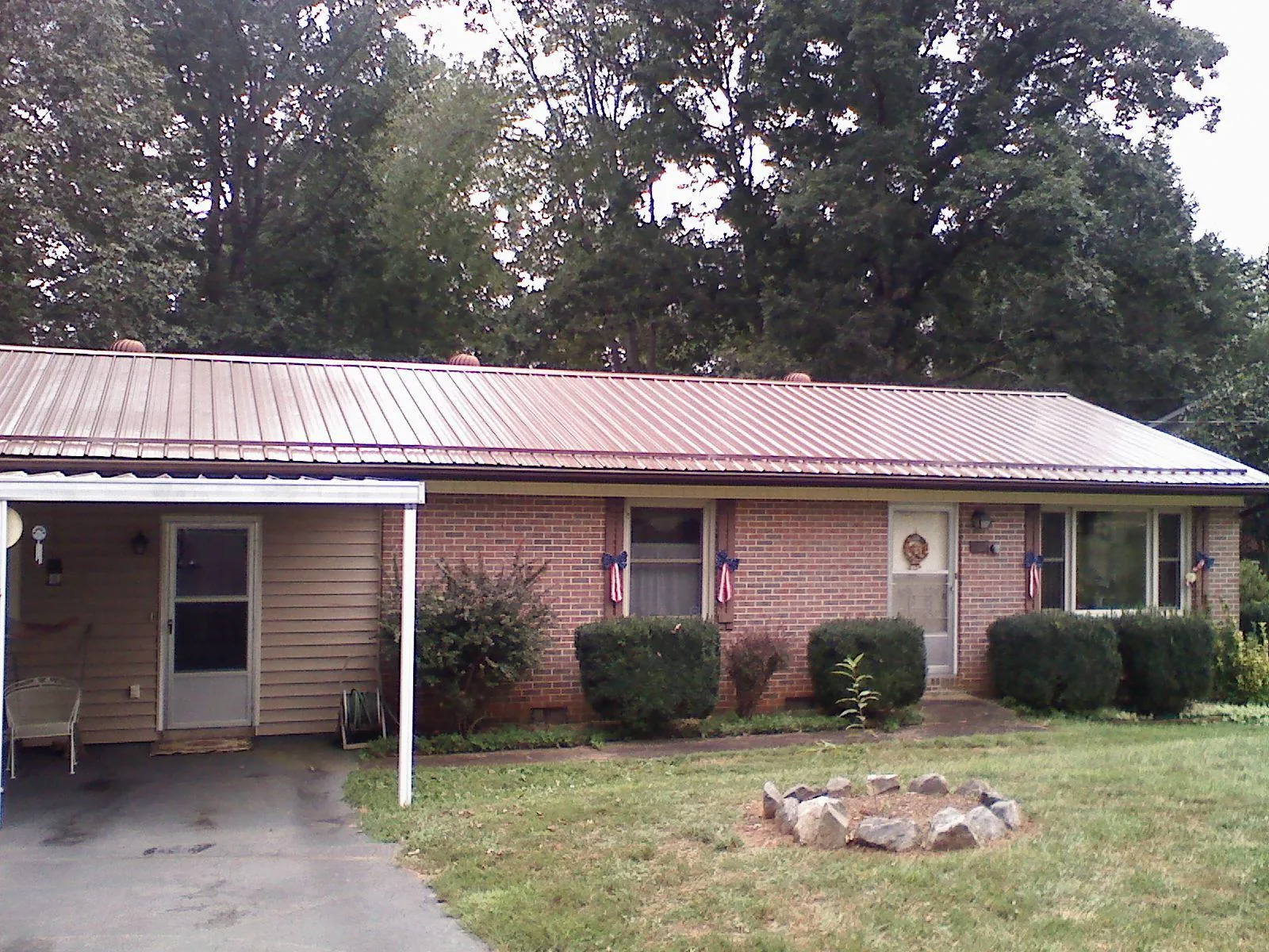Bronze metal roof and carport on a brick ranch home — Roof Repair work by our crew in Tarpon Springs